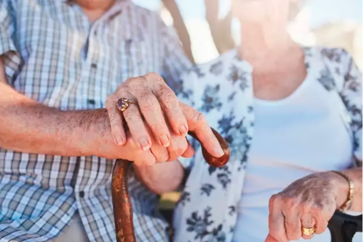 Una pareja de ancianos cruzan sus manos