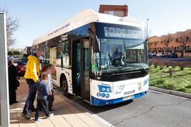 Un hombre y dos niños se disponen a subir al autobús de la línea 5 que une Ciudad Jardín con el barrio de Los Alcaldes.