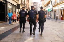 Tres agentes de la Policía Nacional caminan por la calle Toro.