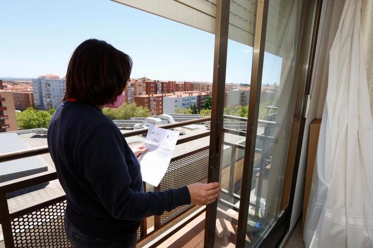 Una de las afectadas sujeta una copia de su denuncia delante de una ventana en su domicilio