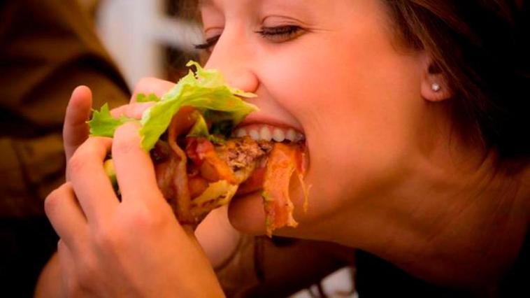 Una persona comiéndose un sandwich.