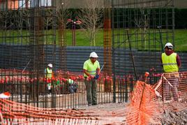 Empleados de la construcción trabajando en las obras de un nuevo edificio en la zona de La Platina