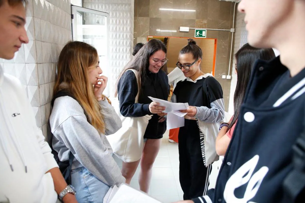 Varias jóvenes consultan sus apuntes en el descanso de los exámenes de la EBAU