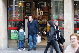 Un hombre sale de un supermercado con la bolsa de la compra