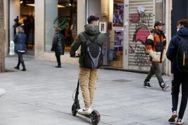 Un joven conduce su patinete eléctrico por una de las aceras más transitadas del centro de Salamanca