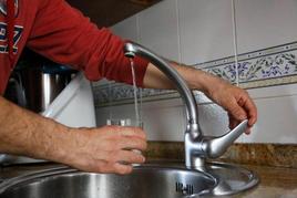 Una persona rellena su vaso con agua del grifo.