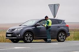 Un agente de la Guardia Civil parando a un turismo.