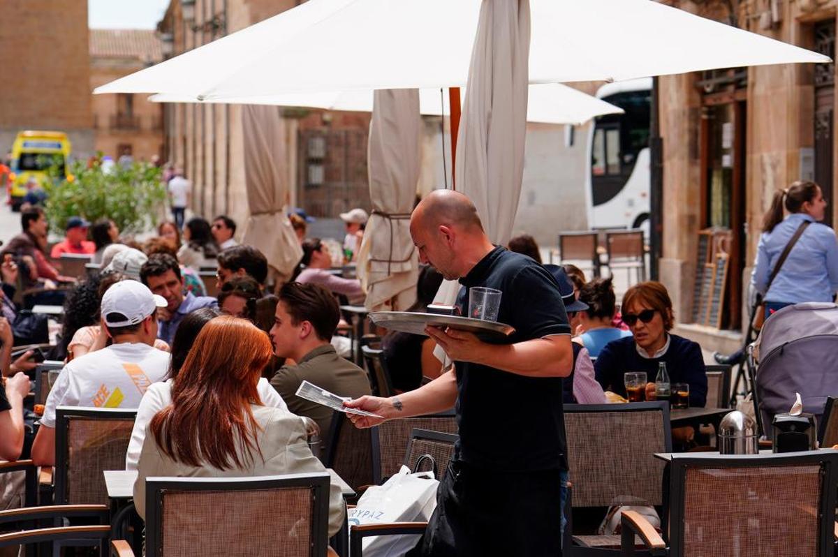 Un camarero atiende a los clientes sentados en una terraza de la Rúa.