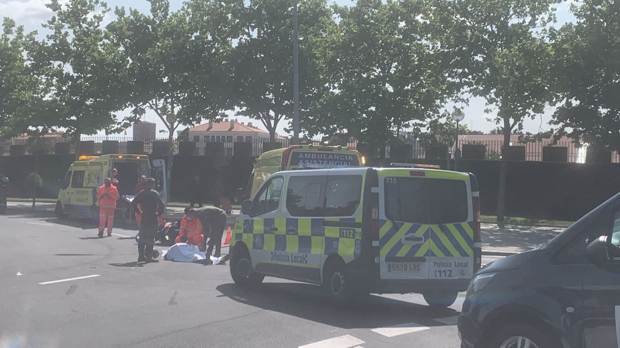 El motorista tendido en el lugar del accidente y atendido por los sanitarios.