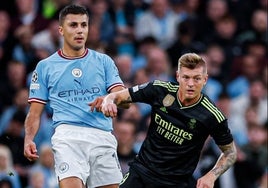 Kroos disputa un balón con Rodri en el partido.