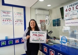 La propietaria del despacho, Eva García, con el cartel del premio ganador.