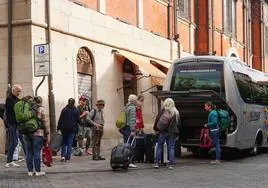 Un grupo de turistas bajan de un autobús en el centro de Salamanca