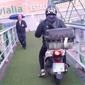 El repartidor de pollos conduce su motocicleta por la pasarela de Vialia.