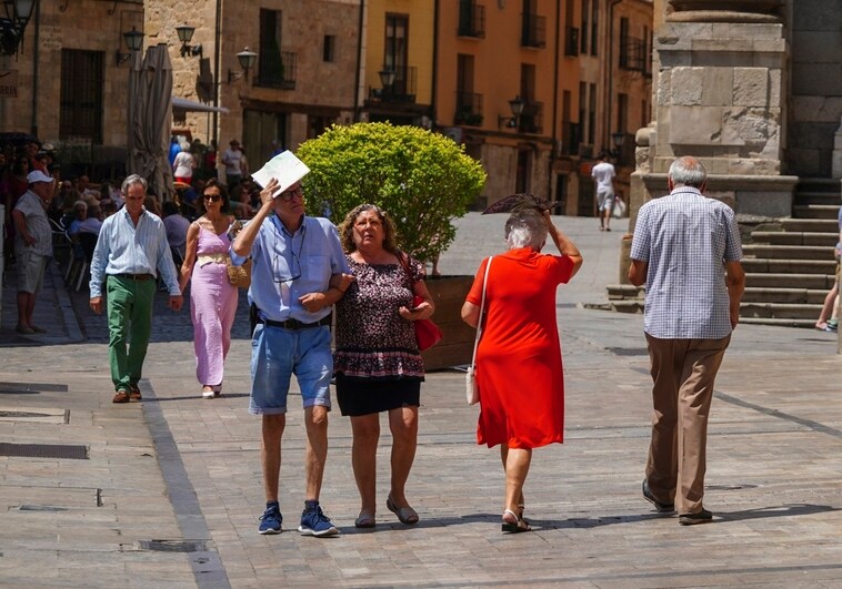 Varias personas se cubren la cabeza durante la última ola de calor en Salamanca.