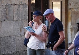 Dos turistas 'luchan' contra el calor refrescándose tomando un helado en la Plaza Mayor.