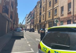 La Policía local ha acordonado la calle Navas mientras los bomberos usan una escala.