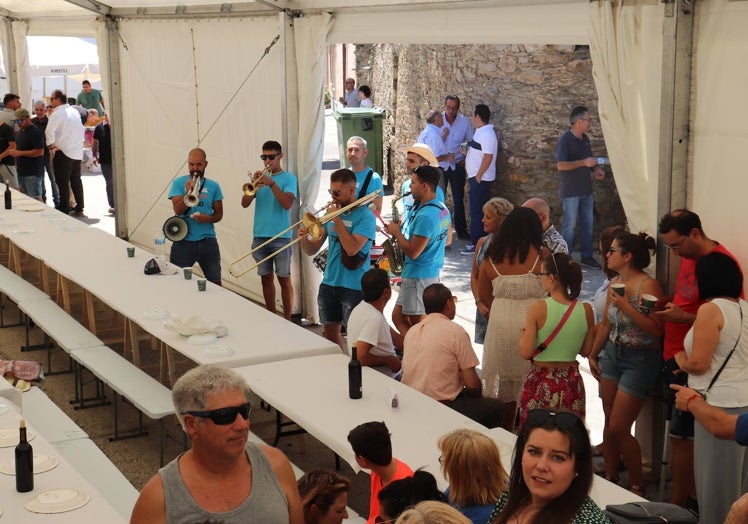 Imagen principal - Vista de la comida del año pasado amenizada por la charanga, los ganadores del concurso de pintura de 2022 y el alcalde. Eusebio García, en el mirador instalado en el patio de armas del castillo de la Mora encantada frente al río.