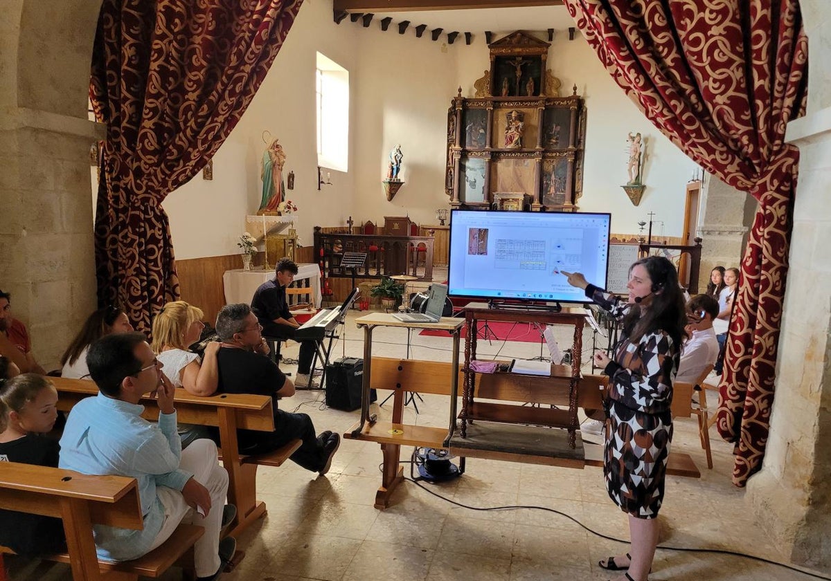 Alejandra del Barrio explicando los pormenores de la restauración de las tablas del retablo de la parroquia de Sepulcro Hilario