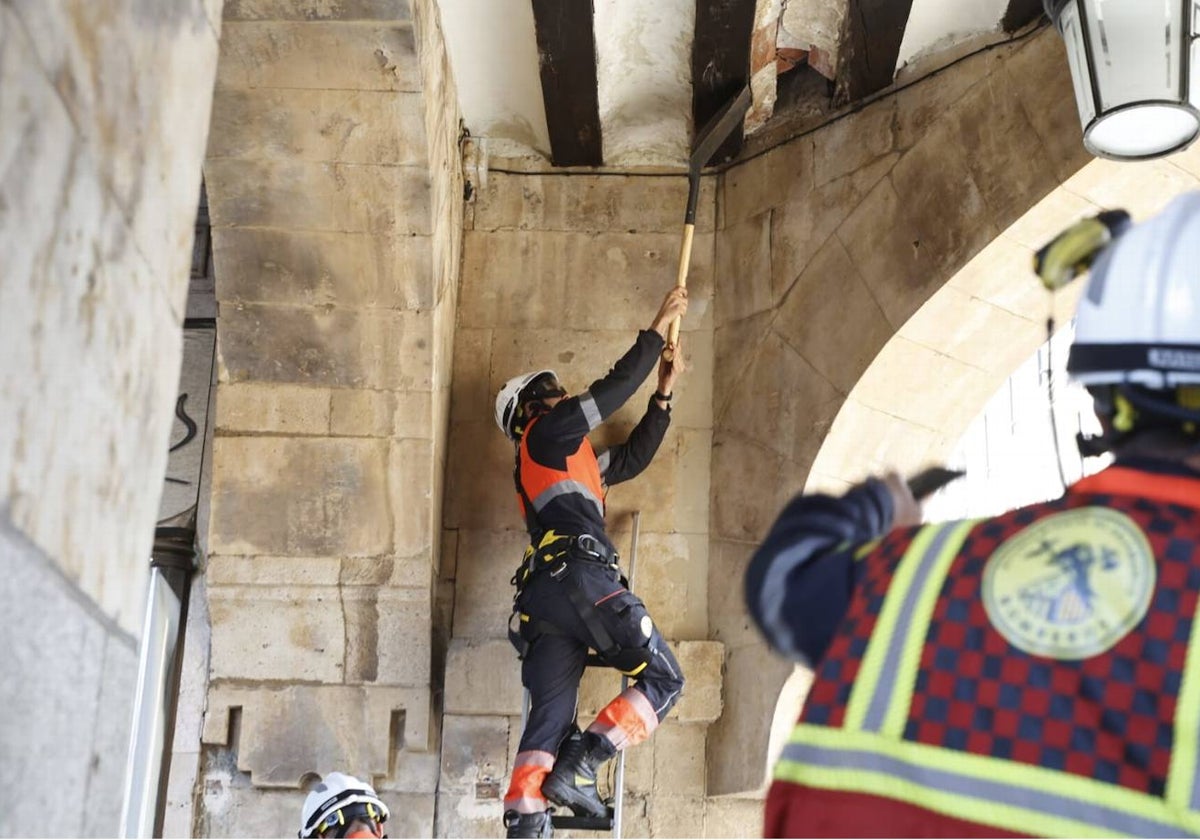 Los bomberos retirando parte de la bovedilla de la Plaza Mayor.