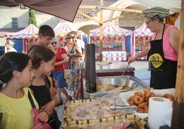 Unos niños mirando la elaboración de dulces artesanos en el mercado de Calzada de Valdunciel