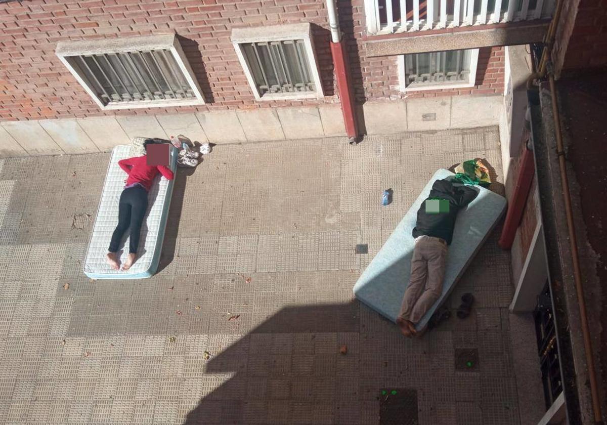 Dos indigentes duermen por la mañana en una de las calles próximas a la estación de autobuses de Salamanca, en el barrio de San Bernardo.