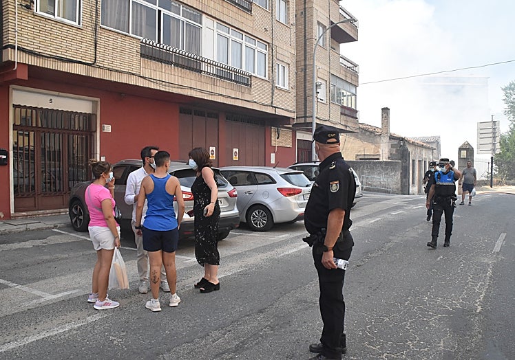 Imagen principal - Imagénes de los vecinos en el exterior de sus viviendas así como el operativo policial y la intensa nube de humo.