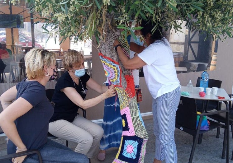 Alumnas participando en el taller de crochet y decorando algunos árboles del municipio