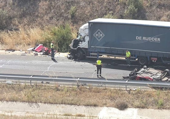 Agentes junto a los vehículos implicados en el lugar del accidente.