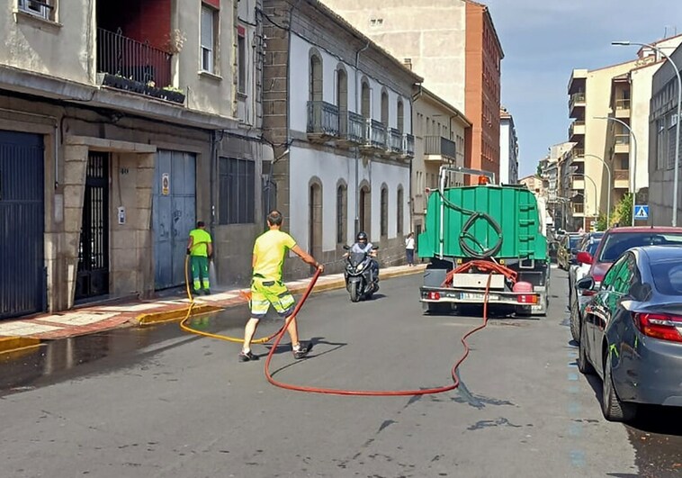 Imagen de operarios de la limpieza baldeando la calle Colón.
