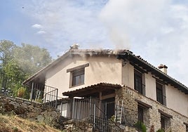 Un bombero intenta sofocar el incendio en la vivienda de Candelario.
