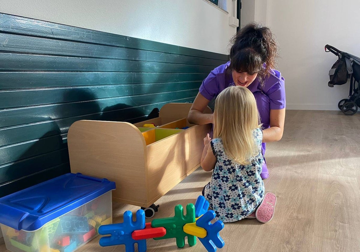 Una educadora con una niña.