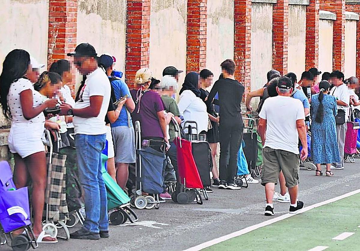 Colas para recoger alimentos a la puerta de la ONG 'Cajas Solidarias'.
