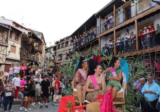 La reina y las damas lanzan caramelos a su llegada a la Plaza Mayor para participar en el desfile