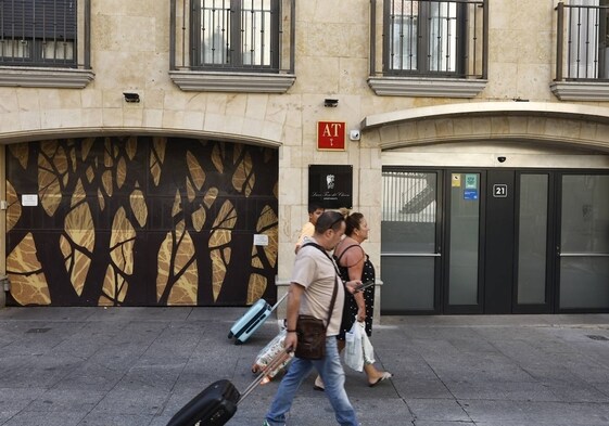 Un grupo de viajeros pasa ante un alojamiento turístico de Salamanca.