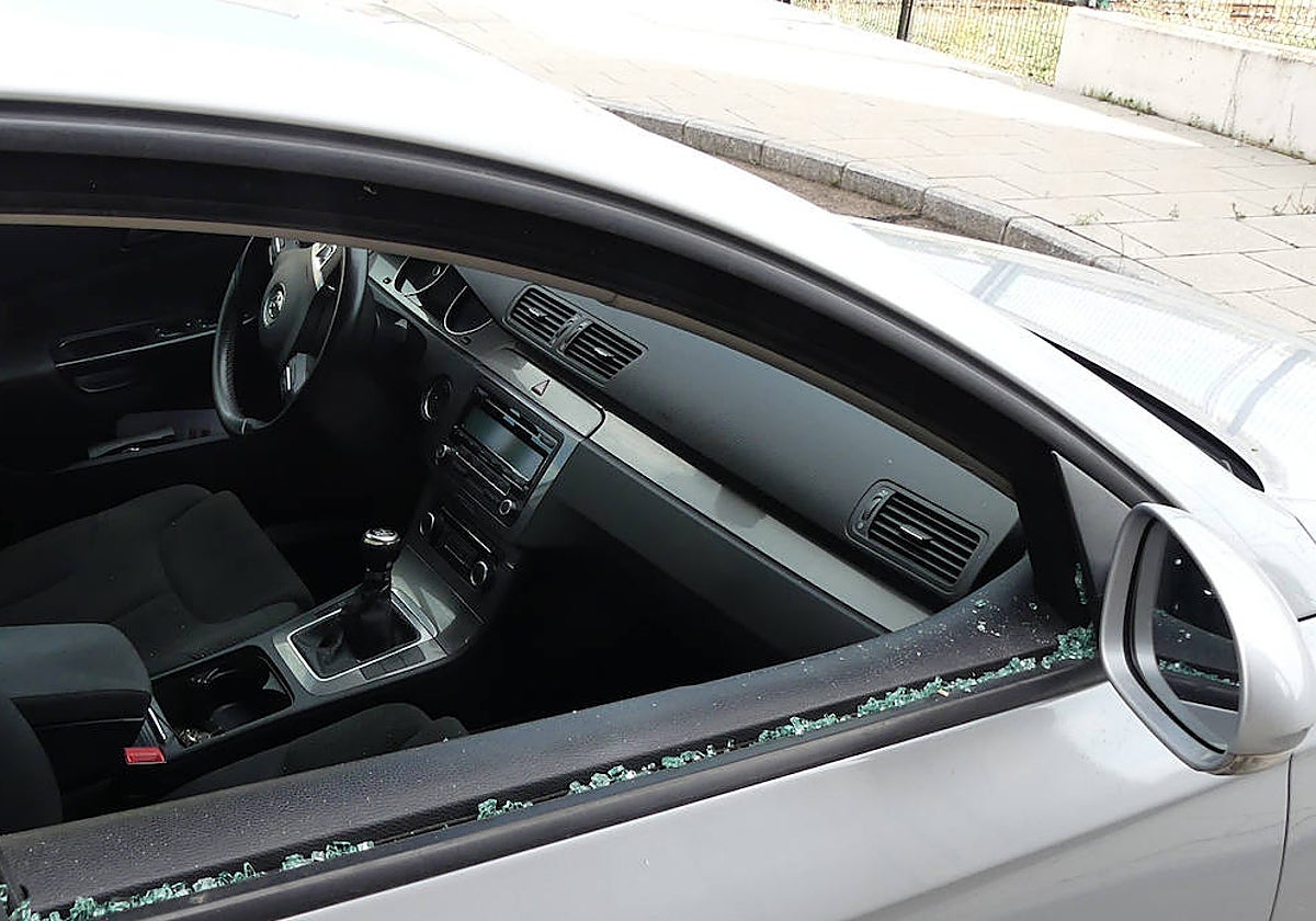 Un coche con la ventanilla fracturada tras un robo.