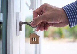 Un hombre abre la puerta de su domicilio.