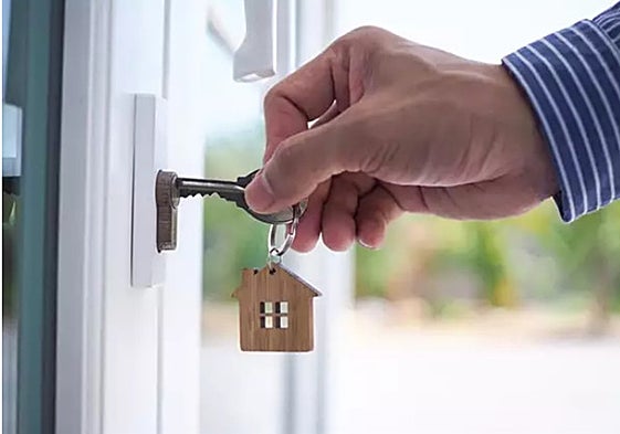 Un hombre abre la puerta de su domicilio.