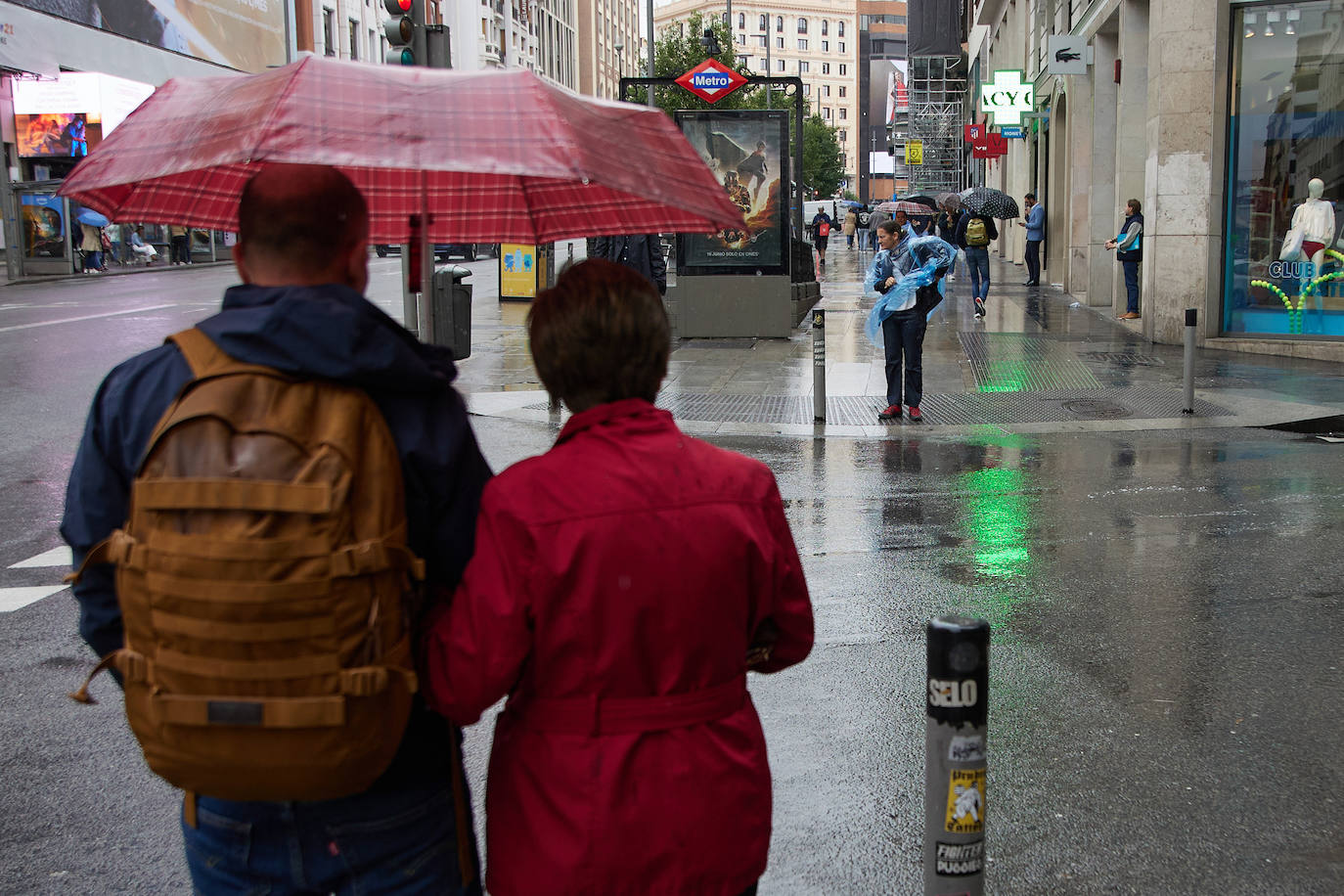 Dos personas transitando por la calle en un día de lluvia