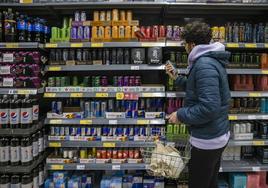 Un joven mira la sección de bebidas energéticas en el supermercado.