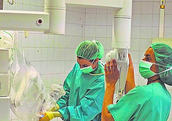 Personal sanitario del Hospital prepara los brazos del Da Vinci antes de una intervención.