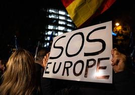 Una persona sujeta un cartel en el que se lee: 'SOS Europa' durante una manifestación contra la amnistía frente al Parlamento Europeo.