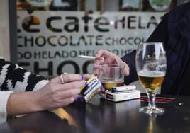 Dos jóvenes comparten tabaco en una terraza de Salamanca.