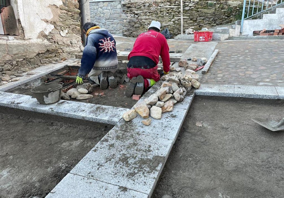 Dos trabajadores ejecutando la obra de renovación en la calle Cuesta del Castillo de Alba de Tormes.