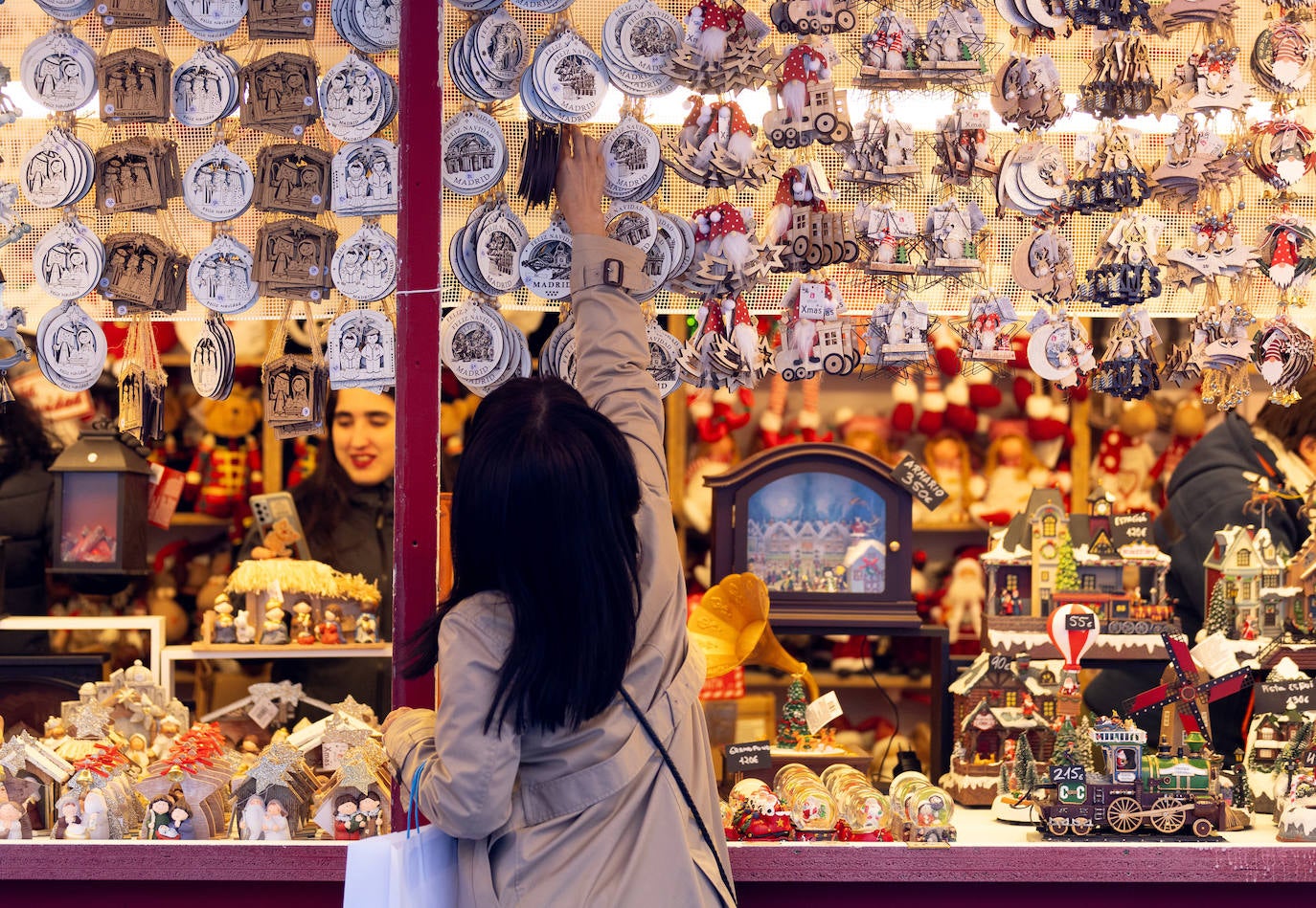 Una mujer observa una caseta del mercadillo de Navidad, en la Plaza Mayor de Madrid.