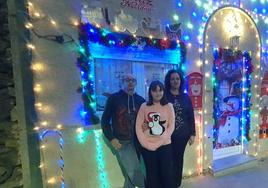 José Andrés, Gabriela y Teresa, junto a su vivienda llena de luces en el barrio bejarano de Palomares.