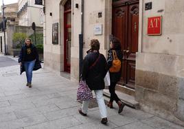 Dos viandantes pasan junto al acceso de un céntrico apartamento turístico.