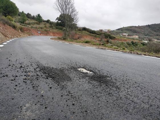 Imagen de un bache aparecido en la carretera recién ampliada con Valdelageve al fondo.