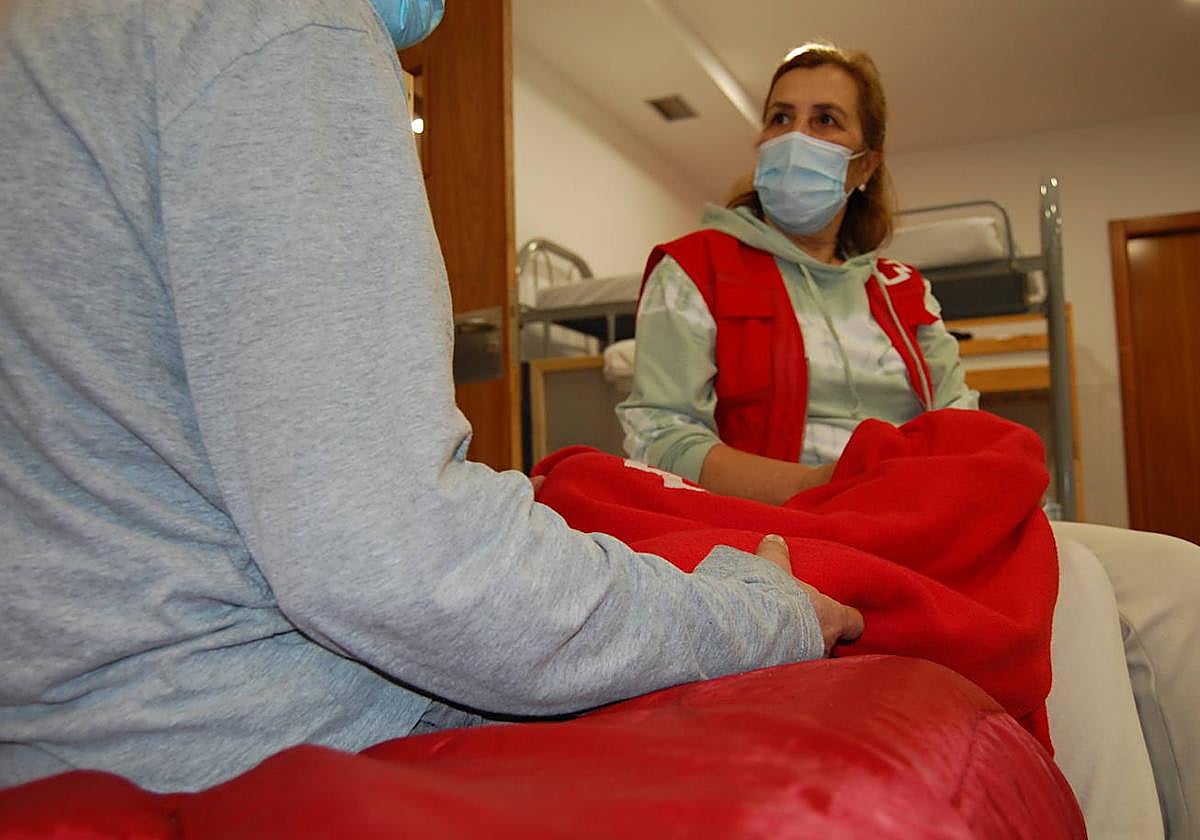 Una trabajadora de Cruz Roja atendiendo a una persona.