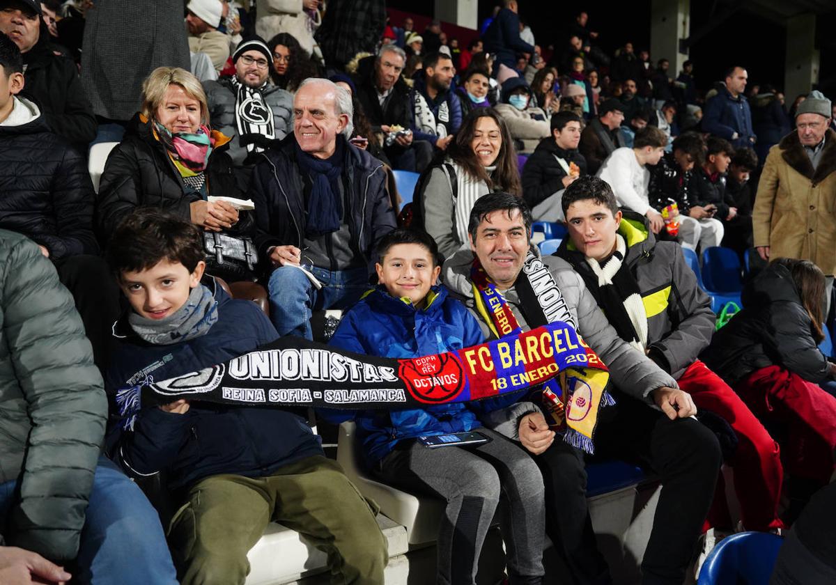 Aficionados posan con una bufanda del partido.