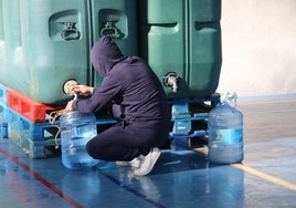 Un vecino llenado garrafas de agua en el frontón cubierto de Santa Marta de Tormes.